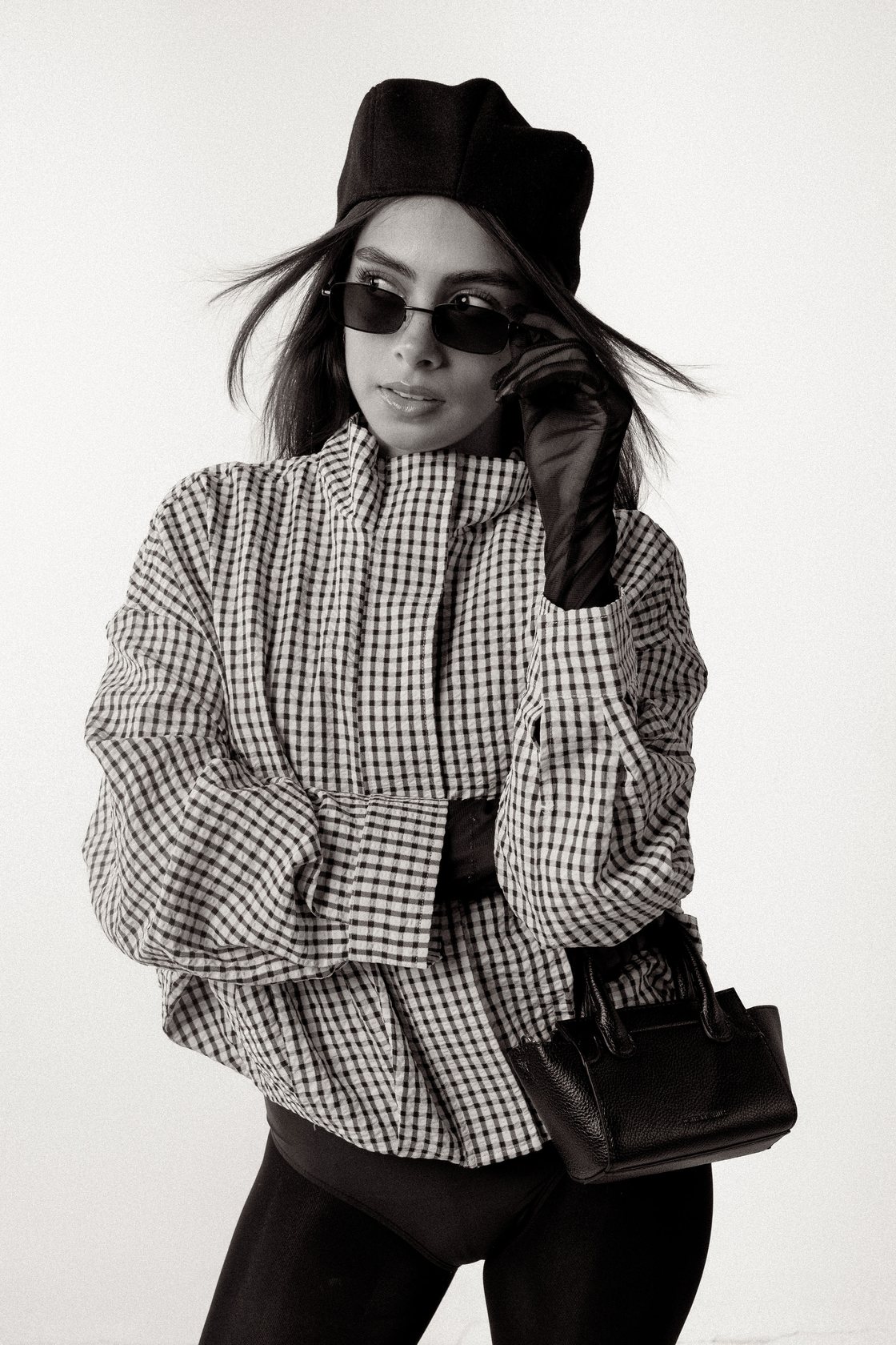 Black and white editorial portrait of Fátima Cecilia with beret, sunglasses and graphic styling
